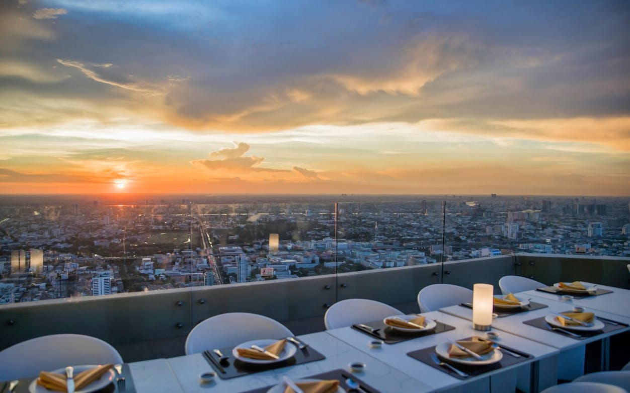 Baiyoke Sky Hotel 18th Floor dining area with city view at sunset.