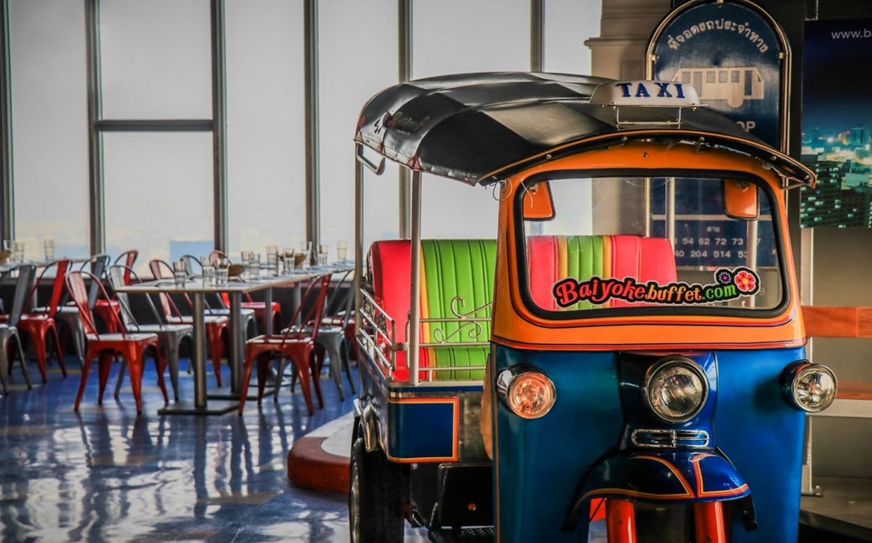 Tuk-tuk inside Baiyoke Sky Hotel's 81st-floor Bangkok balcony buffet area.