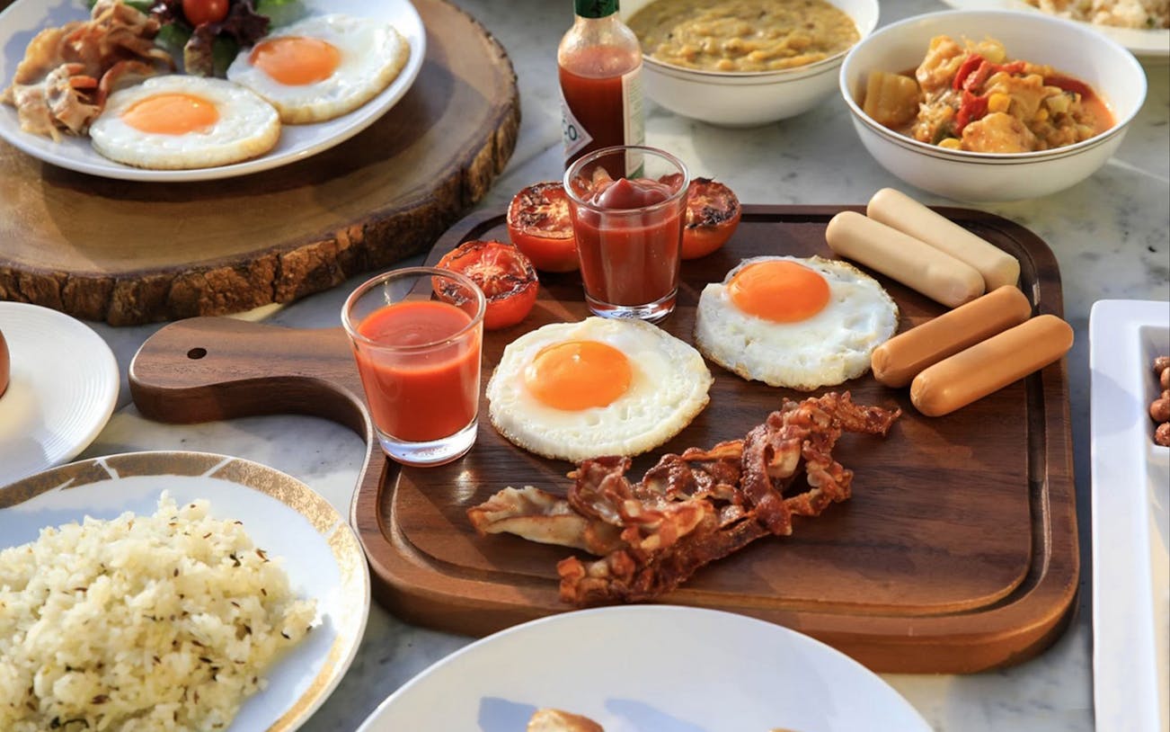 Bangkok Balcony Buffet breakfast with eggs, bacon, sausages, and rice at Baiyoke Sky Hotel's 81st floor.