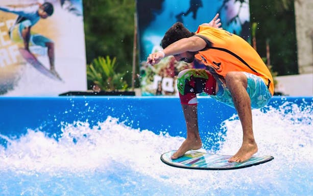 Surfer catching a wave at Surf House Phuket Kata Beach.