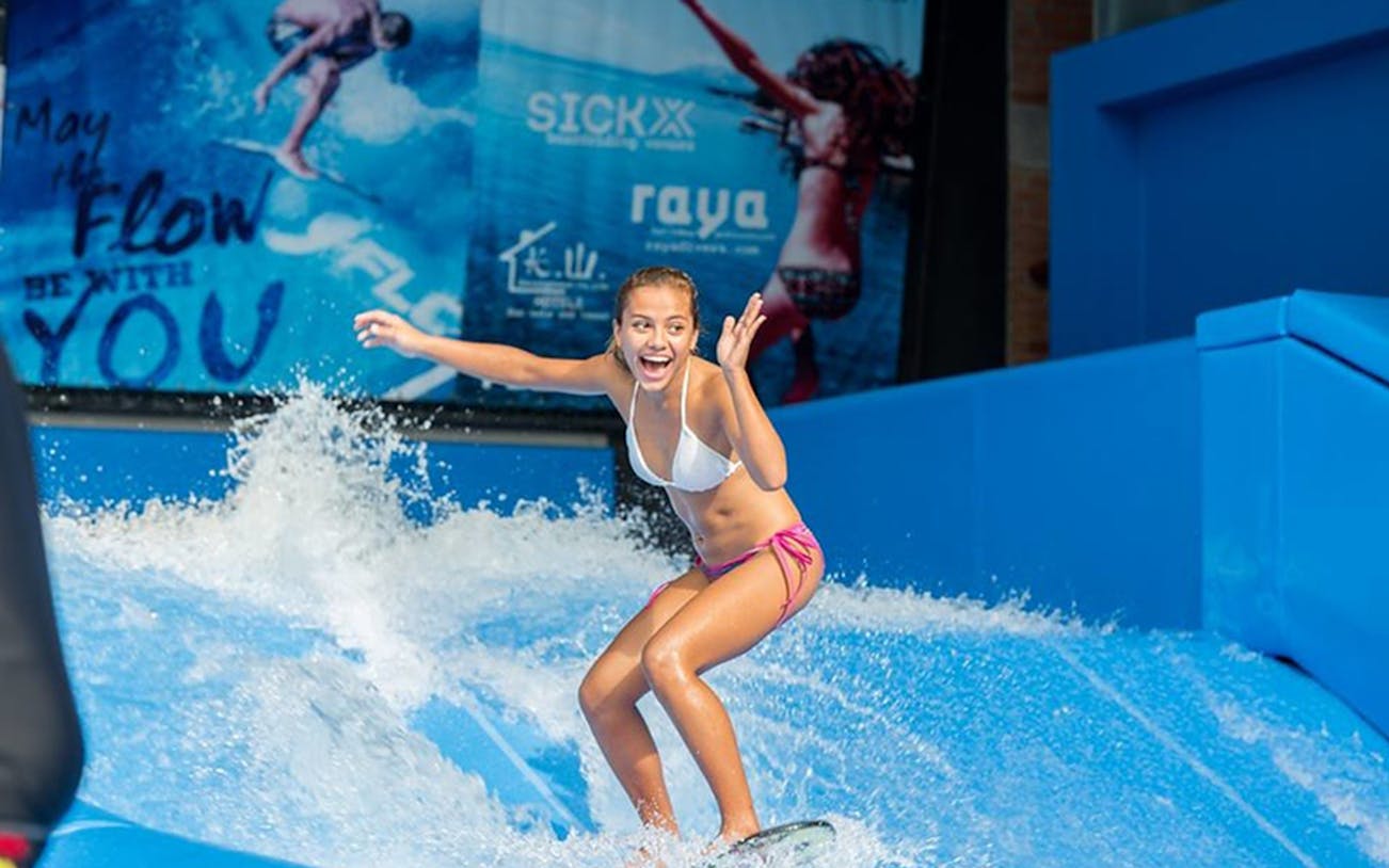 Surfer enjoying wave simulator at Surf House Phuket Kata Beach.