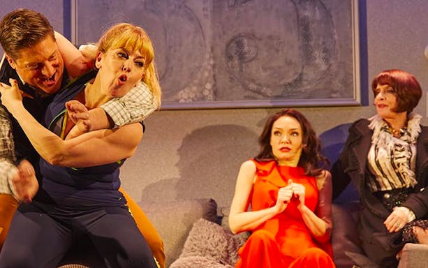 Actors performing a comedic scene in a theater production.