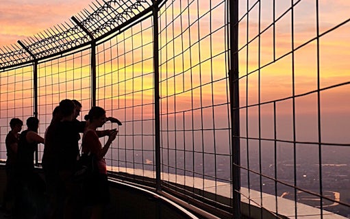 Visitors enjoying sunset views from Baiyoke Sky Hotel's observation deck, Bangkok.