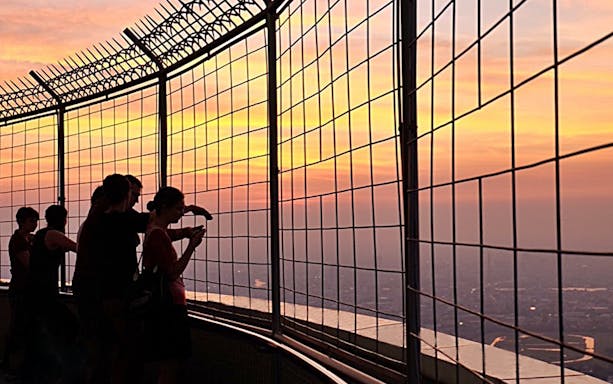Visitors enjoying sunset views from Baiyoke Sky Hotel's observation deck, Bangkok.