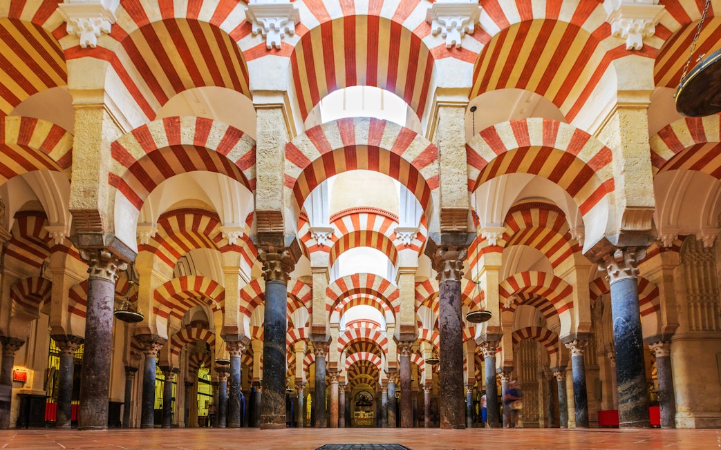 Córdoba Cathedral-Mosque interior with red and white arches and columns.