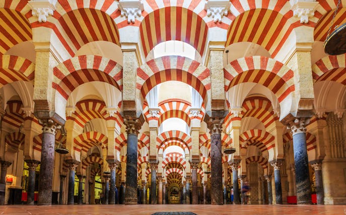 Córdoba Cathedral-Mosque interior with red and white arches and columns.