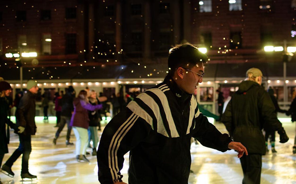 People ice skating at Somerset House in London at night.