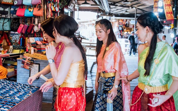 Women in traditional attire shopping at Pattaya Floating Market.