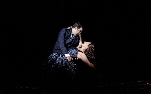 Dancers performing a dramatic pose on stage during a theater show.