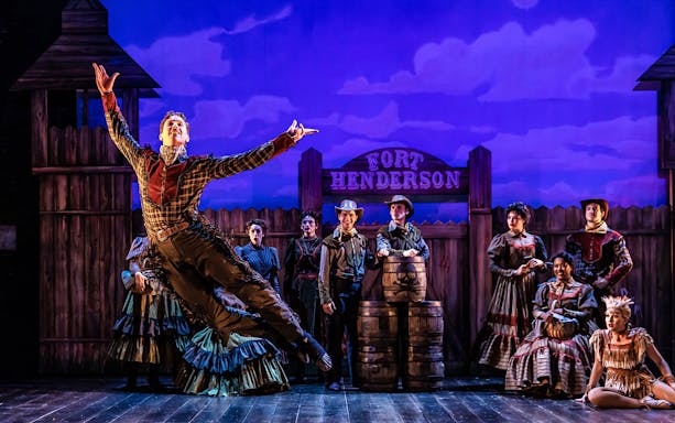 London theater stage with red curtains drawn, highlighting a classic performance setting.