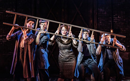 Performers holding a ladder on stage during a scene from the musical "Curtains.