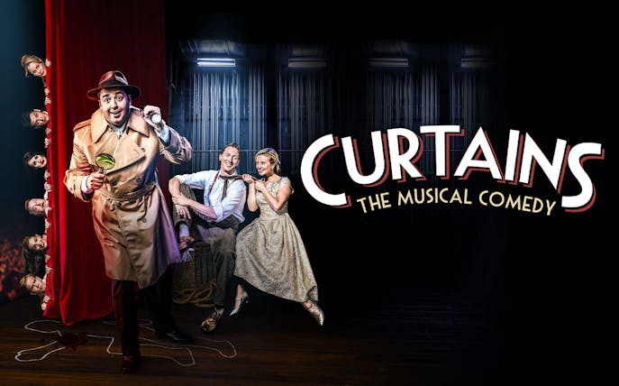 Detective in trench coat with magnifying glass on stage, actors peeking from red curtain, "Curtains" musical.