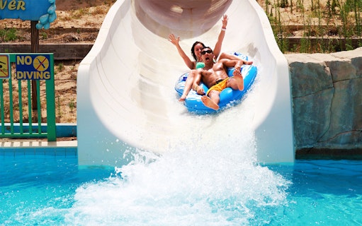 Couple enjoying a water slide at Dreamland Aquapark.