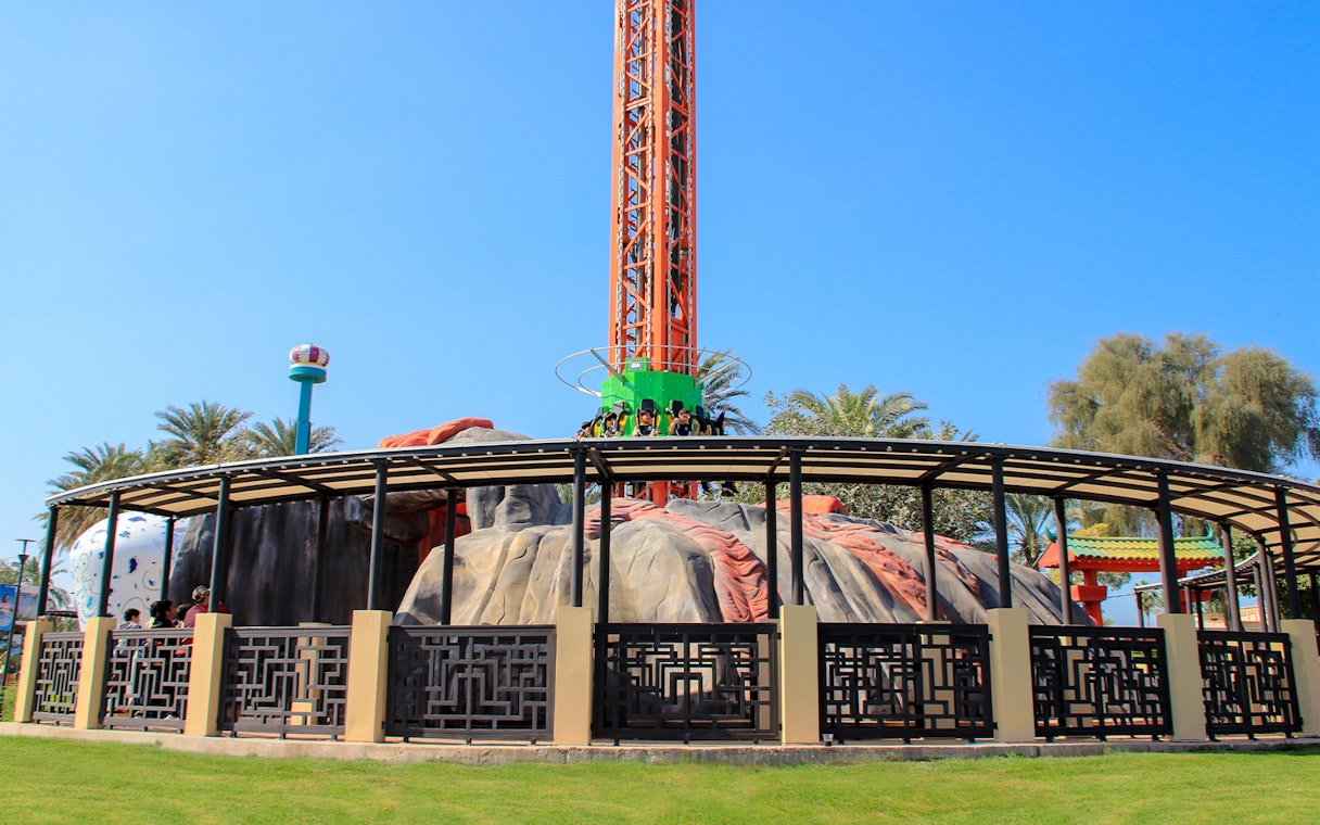 Ride at Al Montazah Water Park with people seated on a vertical drop tower.