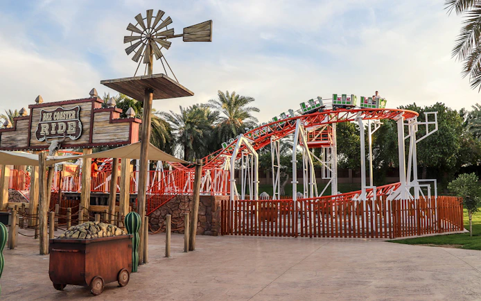 Roller coaster at Al Montazah Water Park with palm trees in the background.