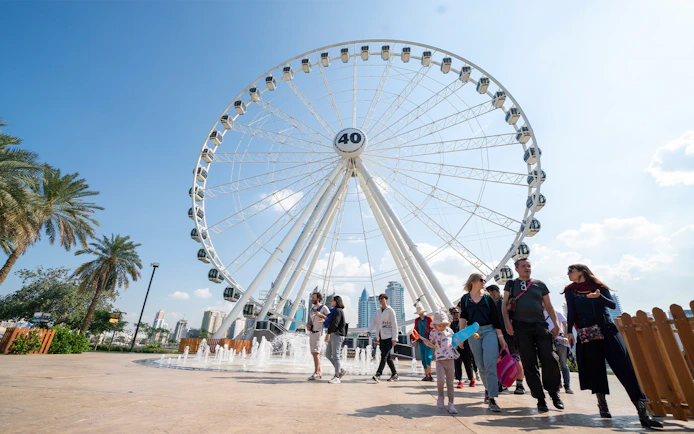 Ferris wheel and visitors at Al Montazah Water Park, Sharjah.