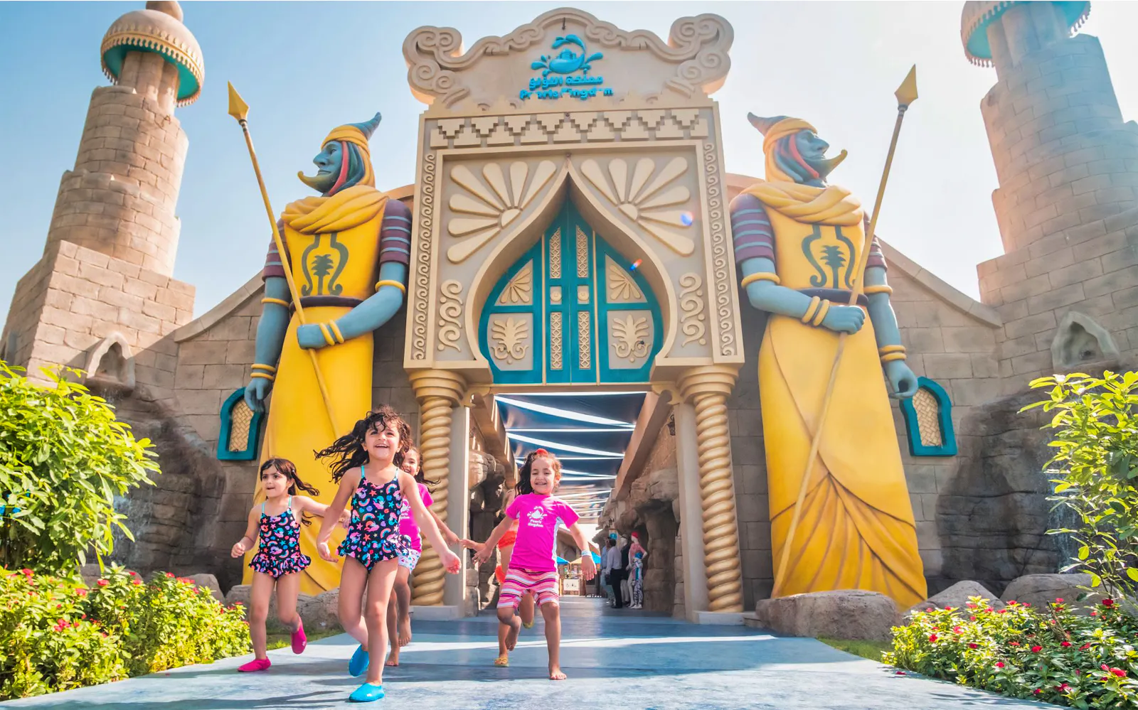 Children run through a colourful themed entrance at Al Montazah Water Park in Sharjah.