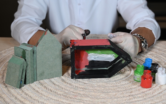 Crafting activity at Qasr Al Hosn with painted wooden blocks and paint jars.