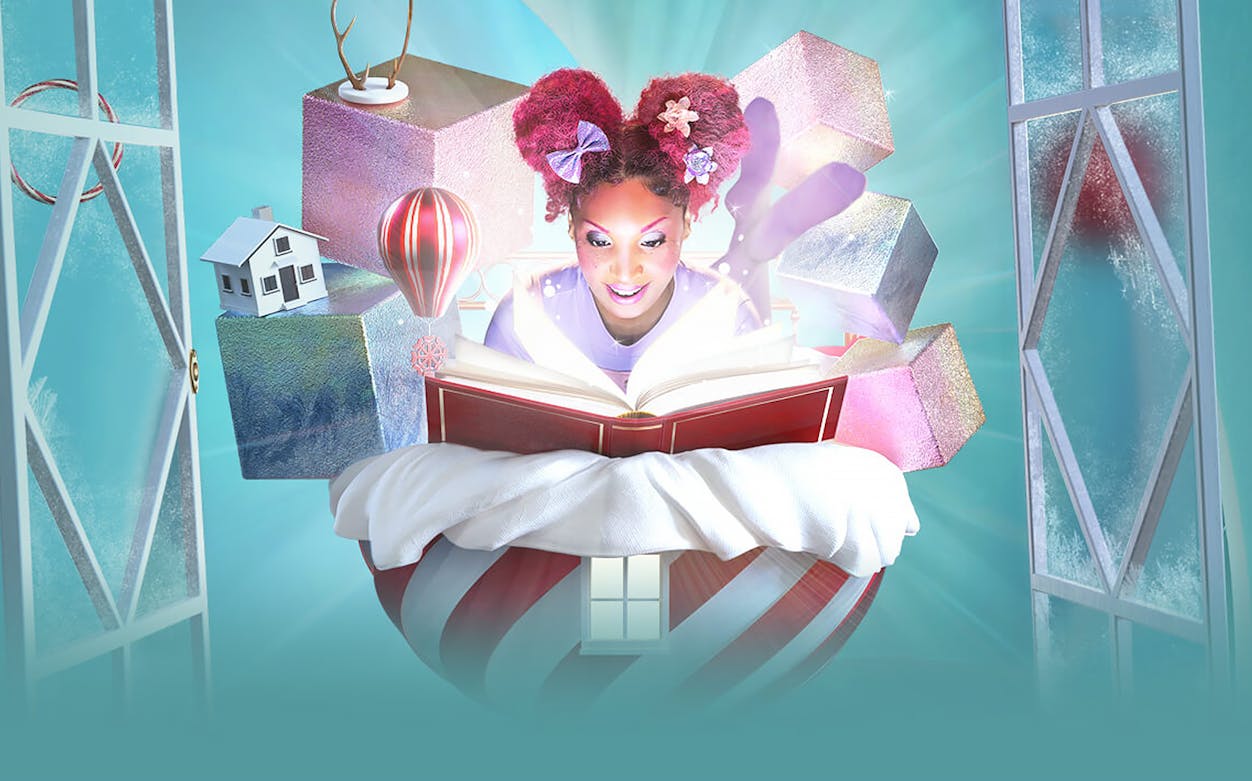 Performer reading a book with magical elements from "Twas the Night Before…" by Cirque du Soleil.