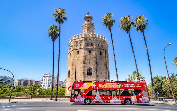 Hop-On-Hop-Off bus in front of Torre del Oro, Seville.