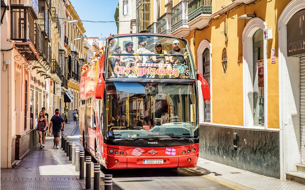 City Sightseeing Hop on Hop off bus on a street in Seville.