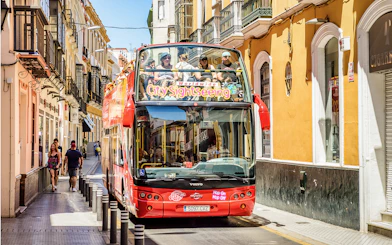 City Sightseeing Hop on Hop off bus on a street in Seville.