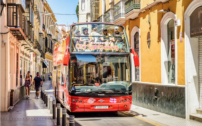 City Sightseeing Hop on Hop off bus on a street in Seville.