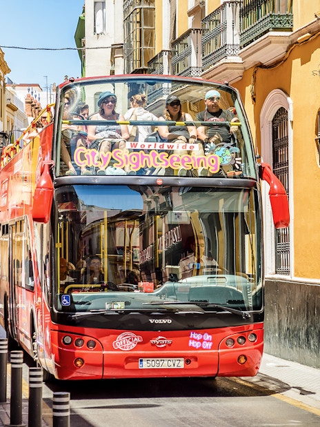 City Sightseeing Hop on Hop off bus on a street in Seville.