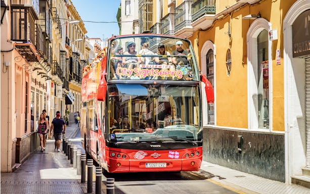 City Sightseeing Hop on Hop off bus on a street in Seville.