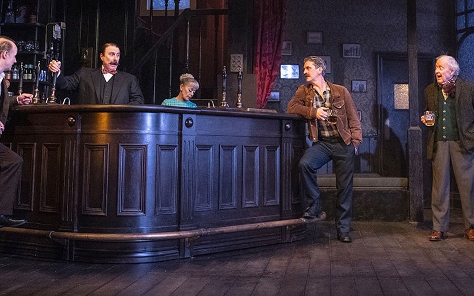Bar scene from the play "Hangmen" with actors in conversation.