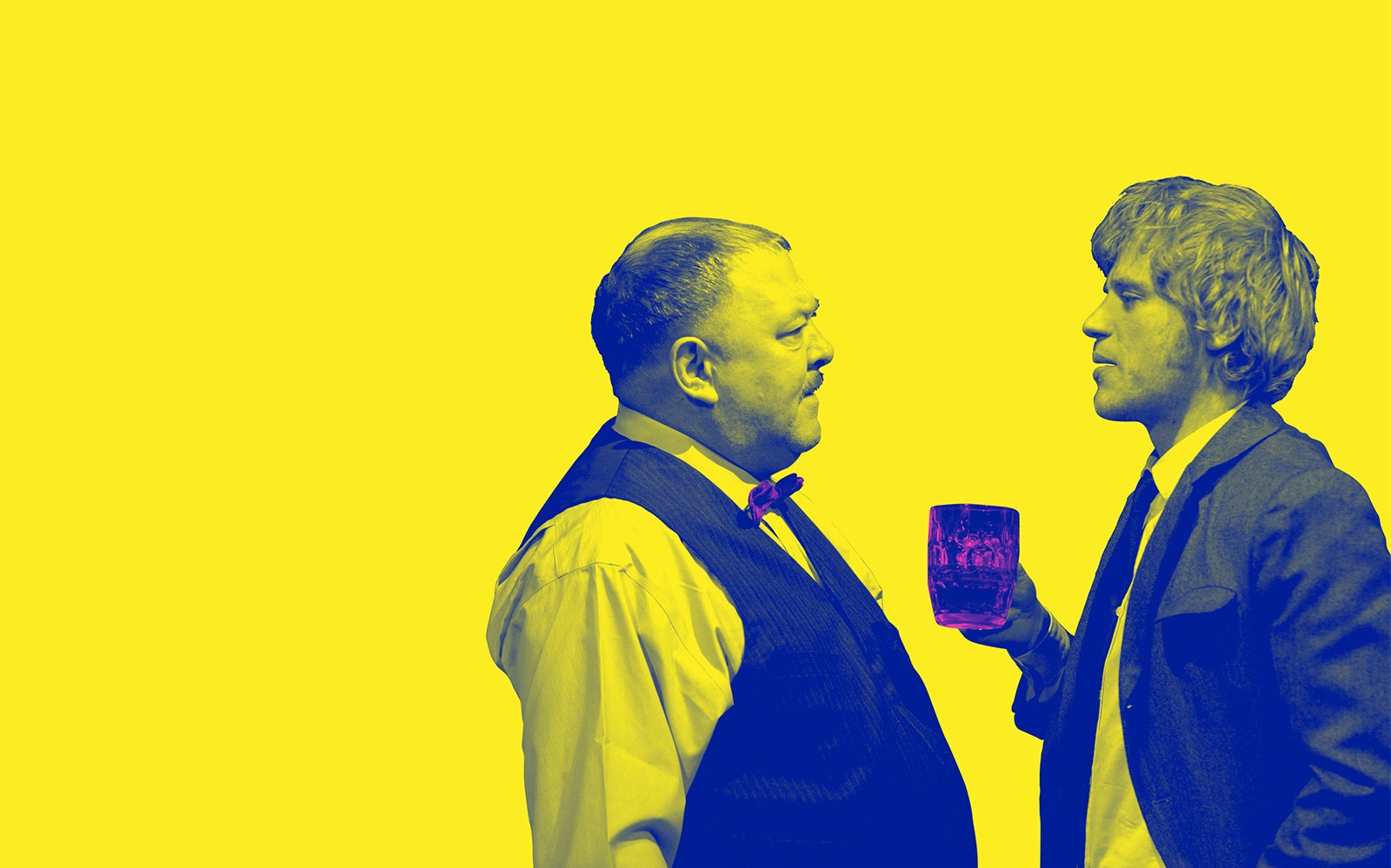 Two men in conversation, one holding a drink, against a yellow background.