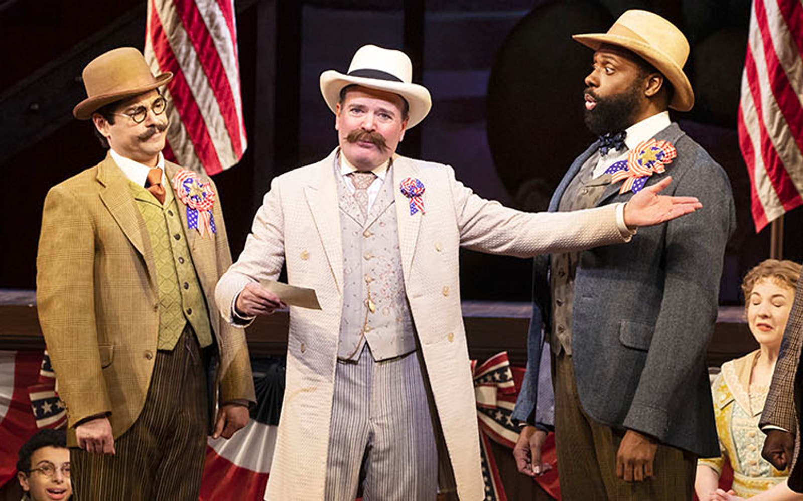 Three actors in period costumes perform a scene from "The Music Man" on stage.