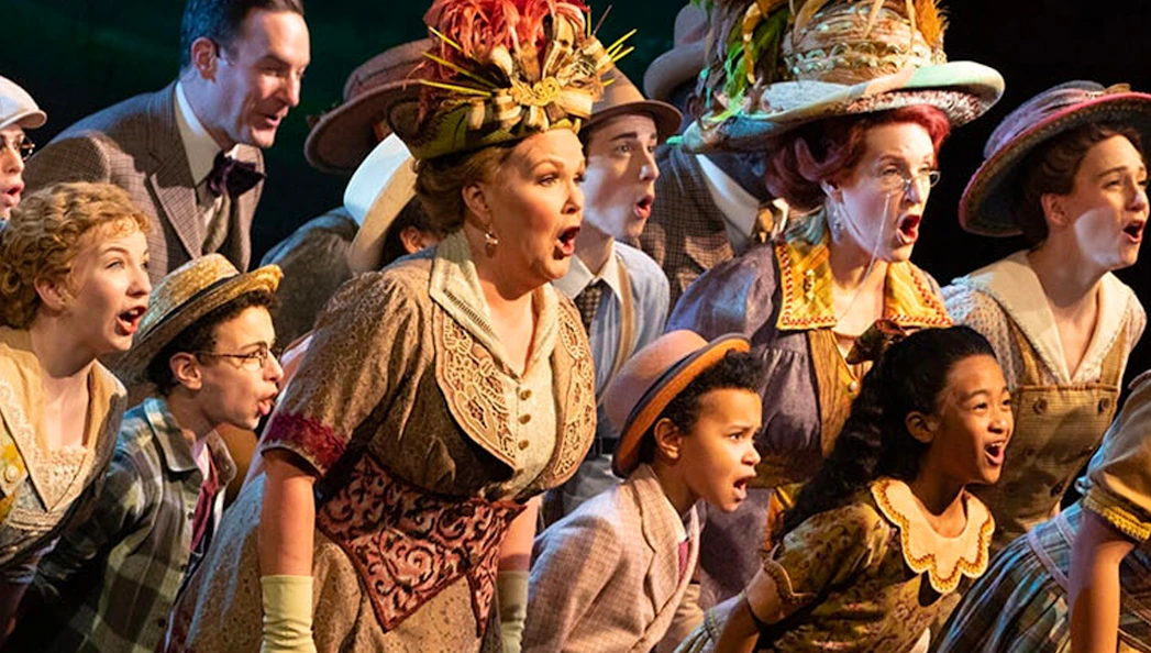 Cast performing a musical number in "The Music Man" with vibrant costumes.