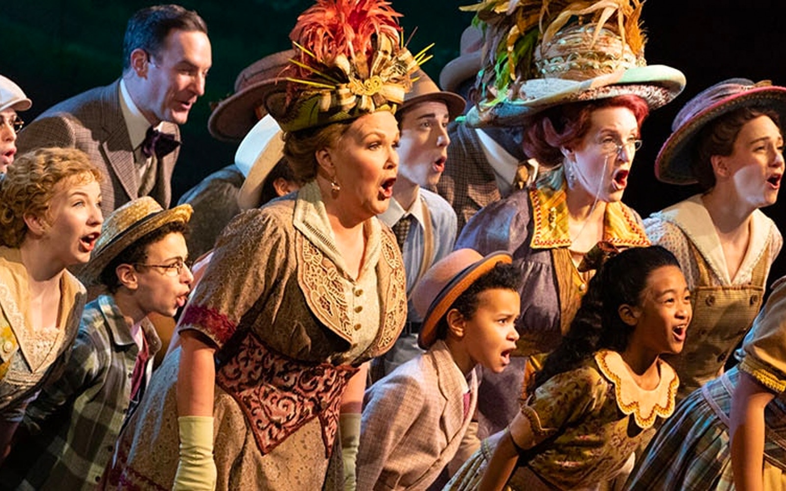 Cast performing a musical number in "The Music Man" with vibrant costumes.