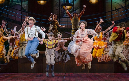 Cast of "The Music Man" performing a lively dance number on stage.