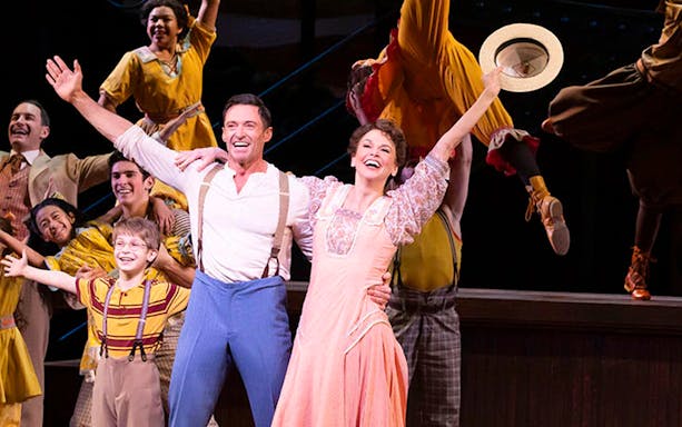 Cast performing a lively scene from "The Music Man" musical on stage.