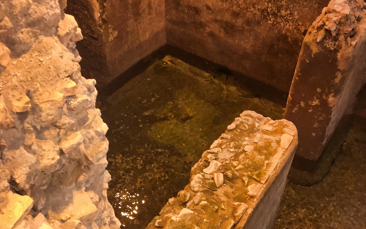 Ancient stone walls and water in Rome's underground near Navona Square.