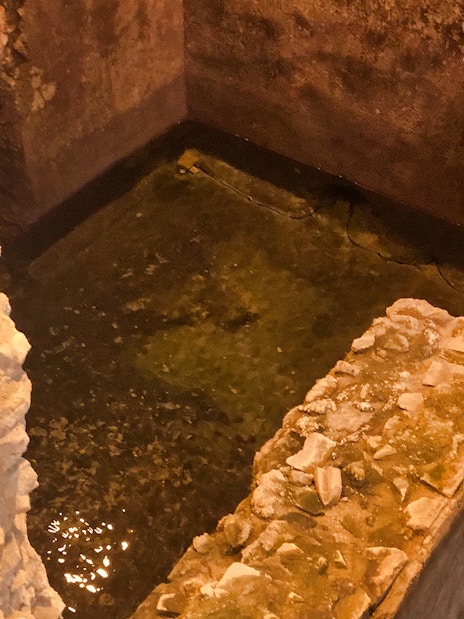Ancient stone walls and water in Rome's underground near Navona Square.