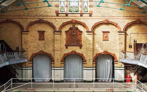 Interior of historic bathhouse with arched brick walls and decorative elements, related to Caracalla Baths Entry & Diocletian Baths Entry.