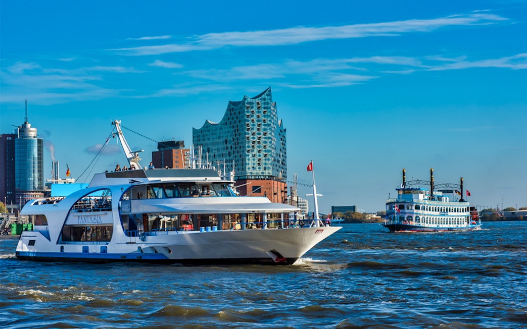 Cruise boats on the Elbe River with Elbphilharmonie in Hamburg.