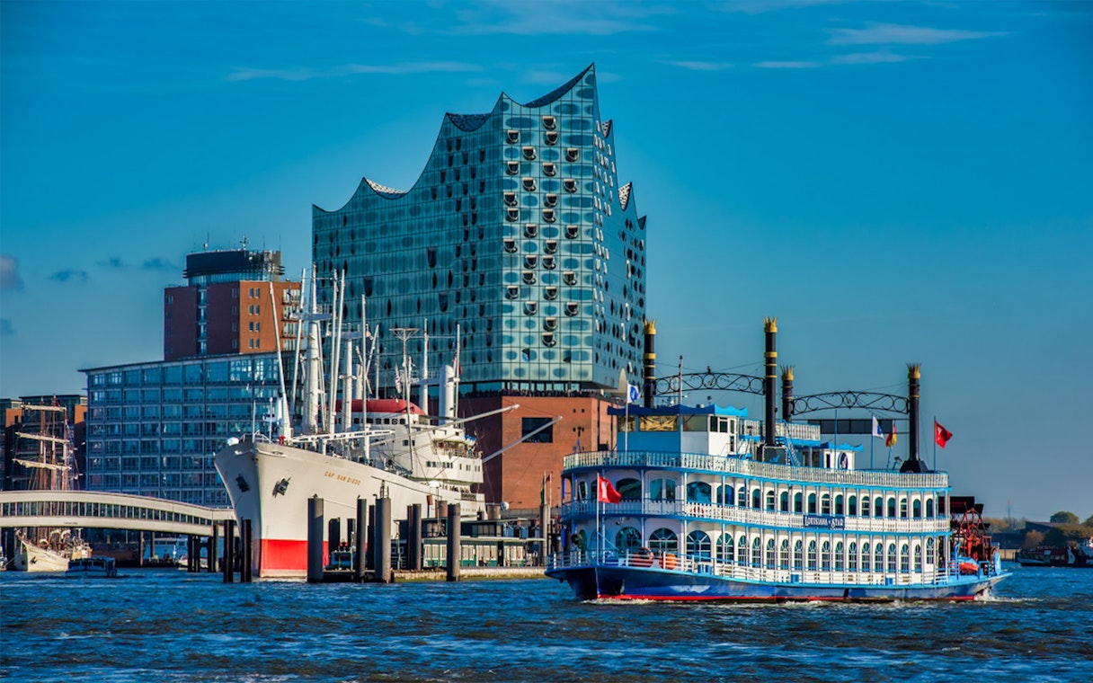 Hamburg river cruise boat near Elbphilharmonie and Cap San Diego ship.