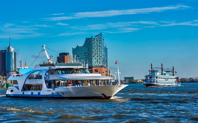 Cruise boats on the Elbe River with Elbphilharmonie in Hamburg.