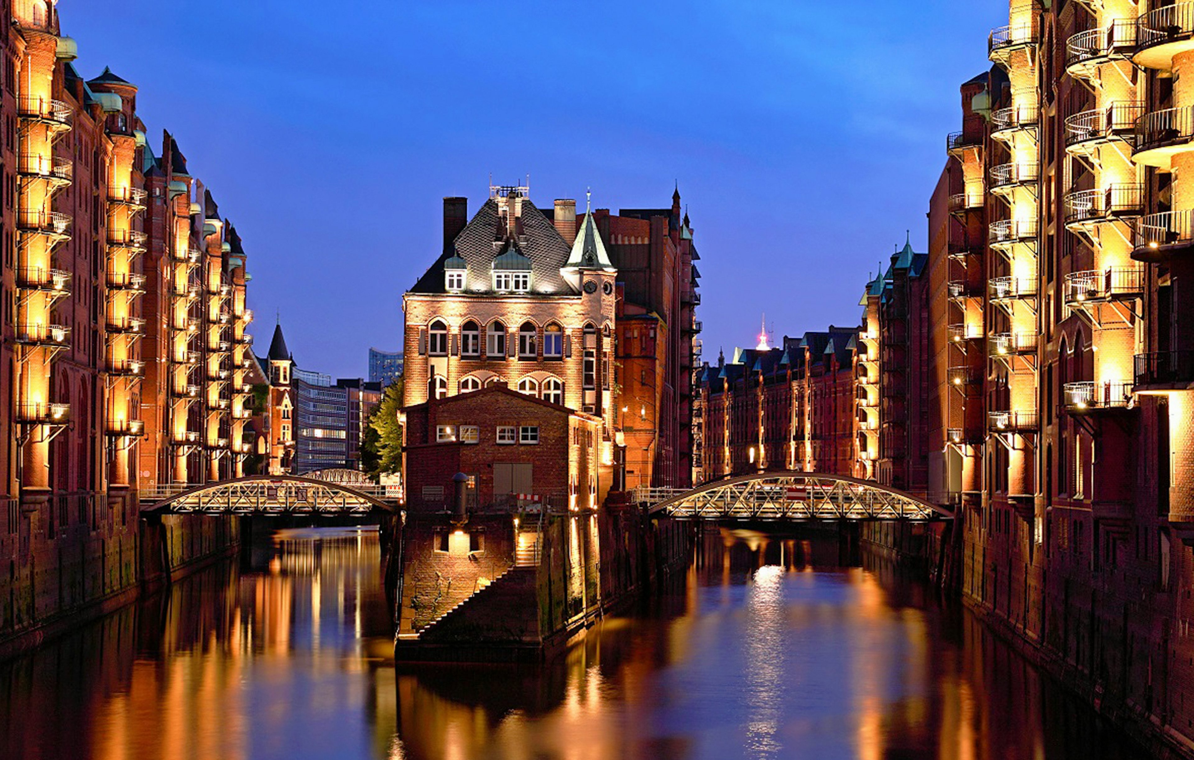 Illuminated Speicherstadt warehouses at night during Hamburg Harbour cruise.