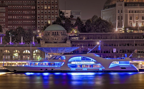 Illuminated cruise ship at Hamburg Harbour during night tour.