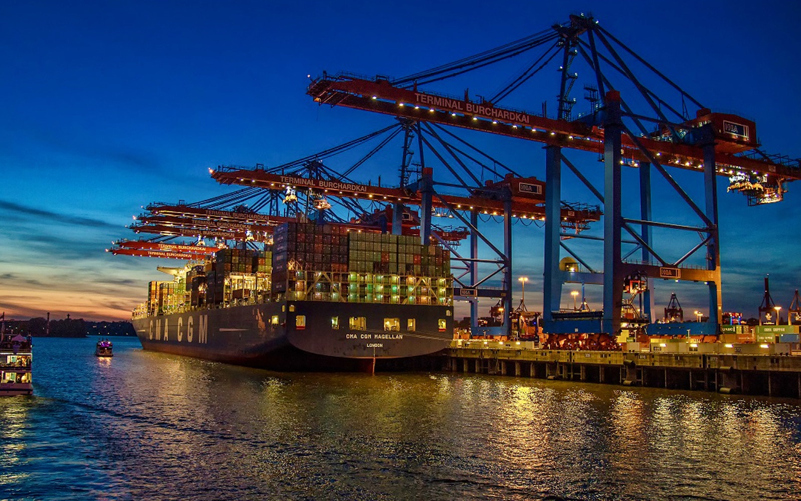 Evening view of illuminated Hamburg Harbour during a cruise tour.