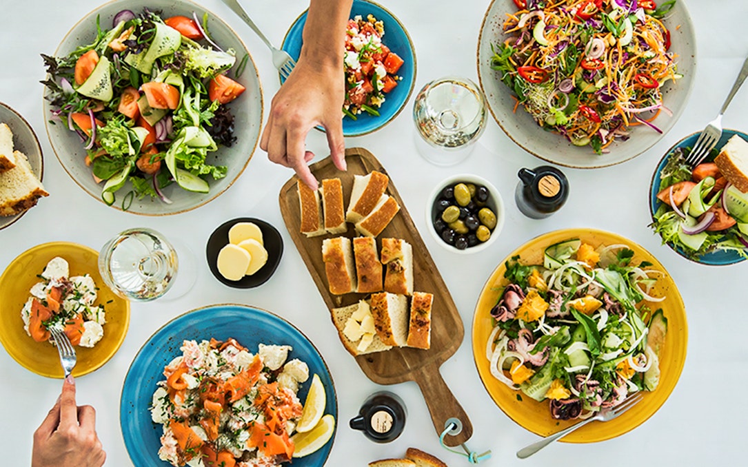 Sydney Tower Buffet dishes with salads, bread, and seafood on a table.