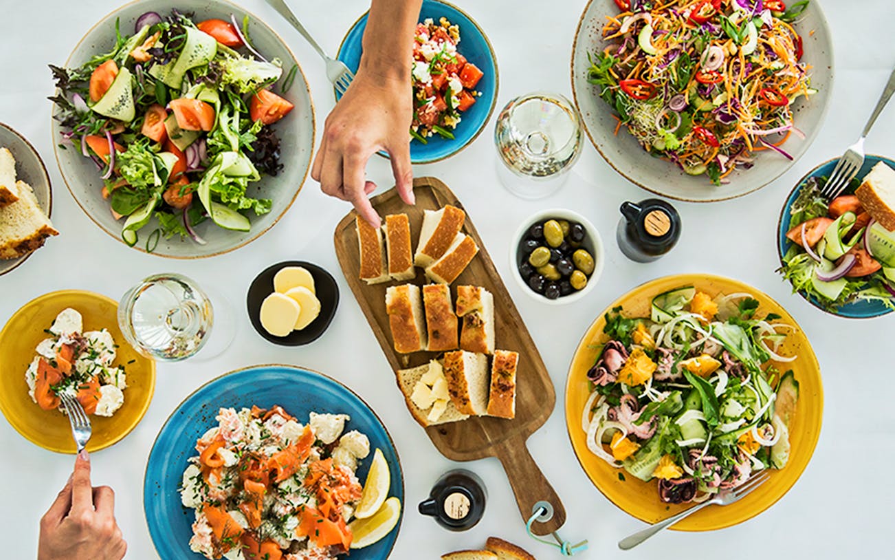 Sydney Tower Buffet dishes with salads, bread, and seafood on a table.