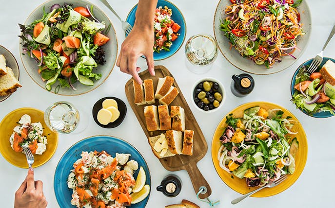 Sydney Tower Buffet dishes with salads, bread, and seafood on a table.