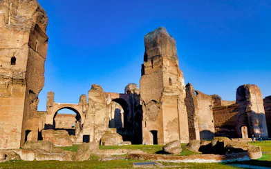 Ruins of the Baths of Caracalla in Rome under a clear blue sky.
