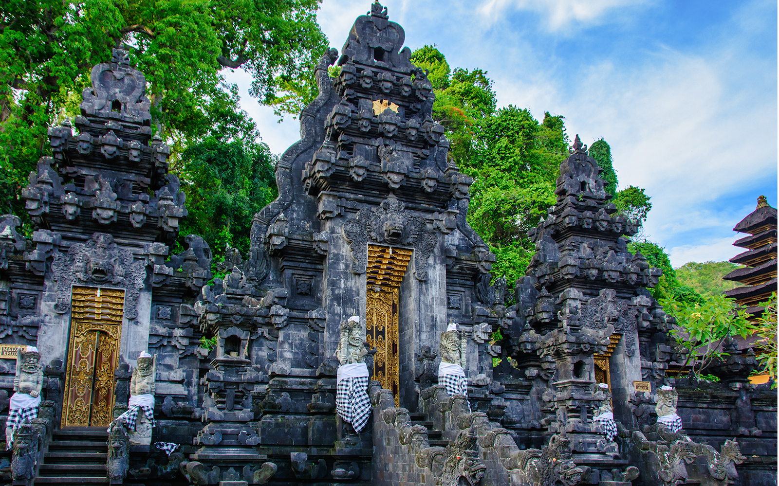 Ubud temple complex with ornate stone carvings and lush greenery in Bali.
